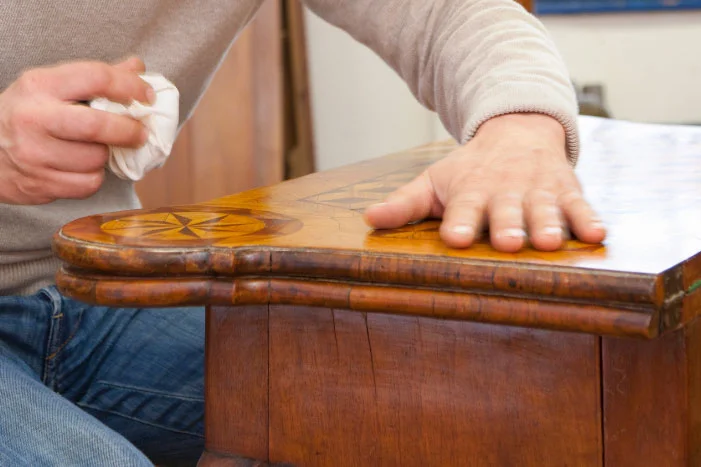 Person poliert Holzoberfläche